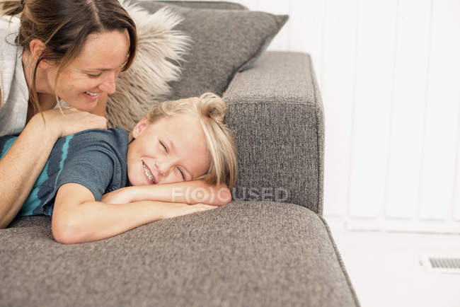 Madre e figlio sdraiati sul divano — Foto stock