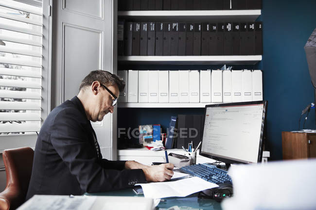 Geschäftsmann sitzt am Schreibtisch in einem Büro — Stockfoto