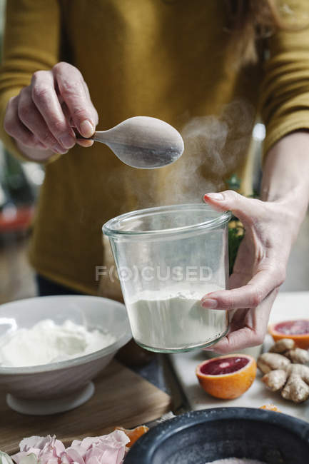 Mulher misturando ingredientes em um pote — Fotografia de Stock