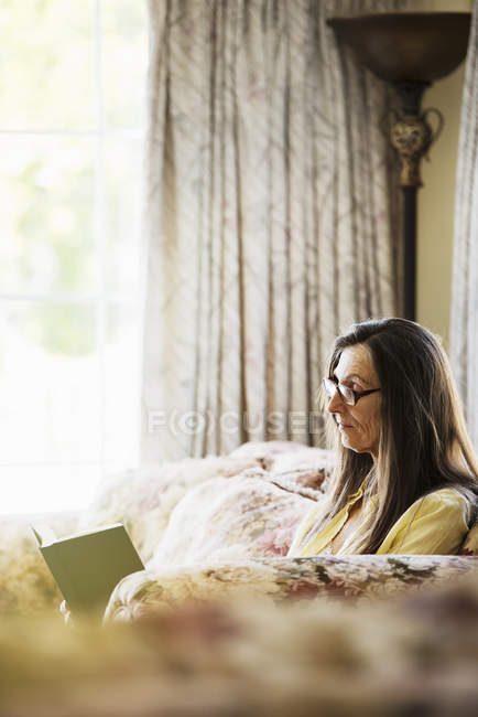 Donna anziana che legge un libro — Foto stock