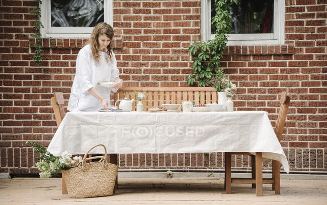 Mulher em pé ao lado de uma mesa — Fotografia de Stock