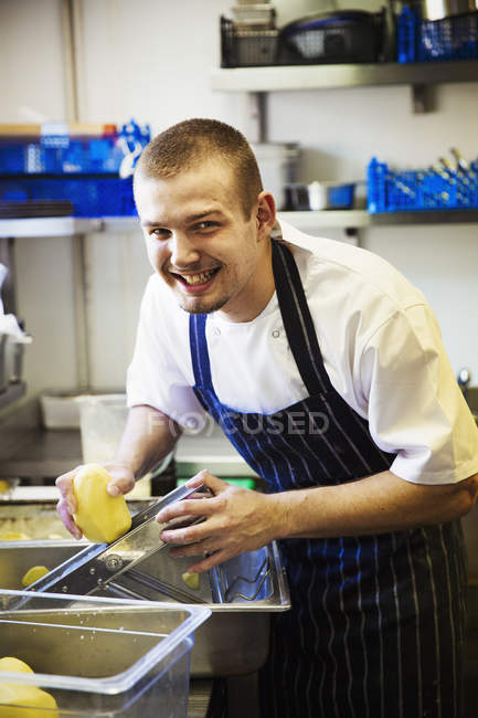 Chef usando cortador de bandolim em batatas — Fotografia de Stock
