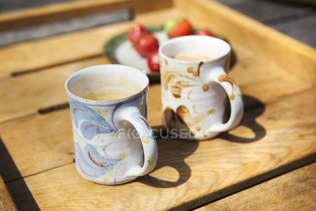 Mugs and a plate of fruit — Stock Photo