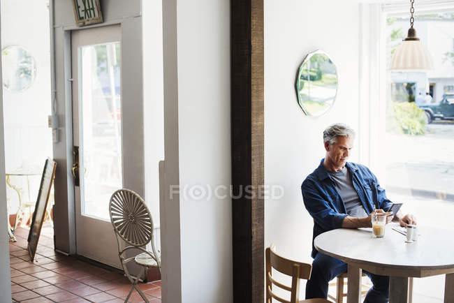 Hombre sentado en la cafetería - foto de stock