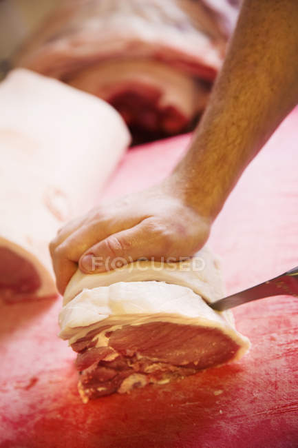 Koch schneidet Gelenk von rohem Fleisch — Stockfoto