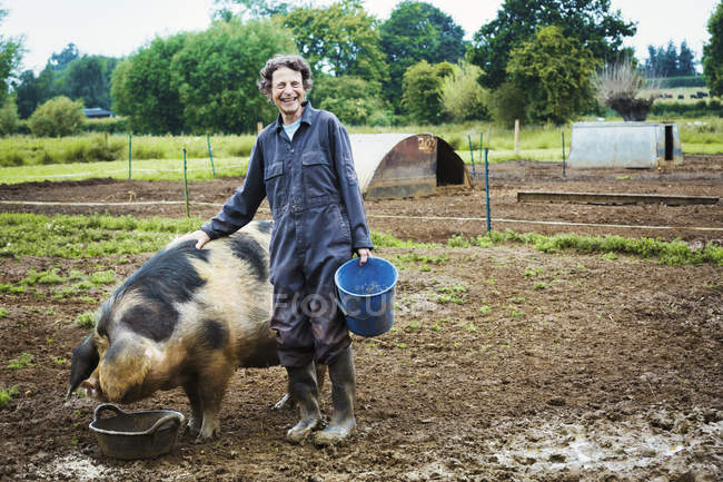 Donna in piedi accanto a grande maiale — Foto stock