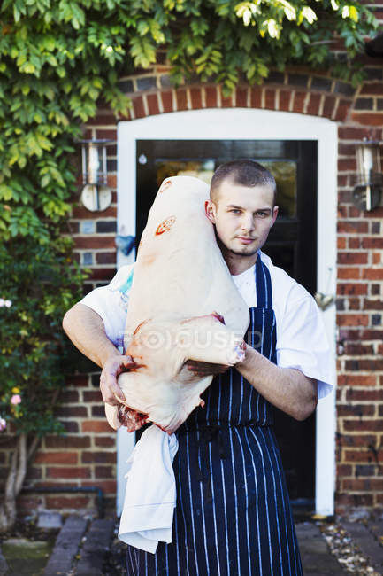 Koch trägt große Tierkadaver — Stockfoto