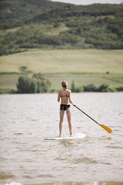 Девушка встает на подножку серфинга — стоковое фото