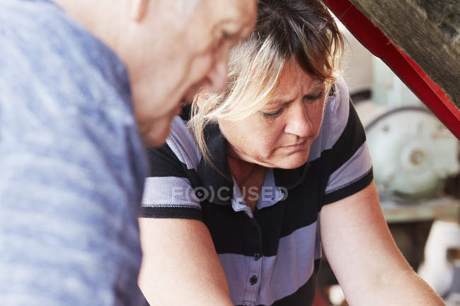 Mulher e homem sênior reparando um carro — Fotografia de Stock