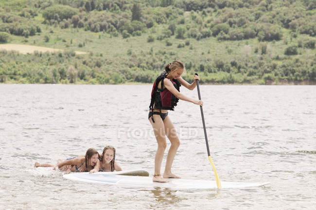 Chica de pie paddle surf - foto de stock
