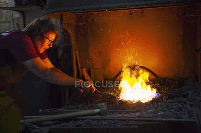 Blacksmith using tongs — Stock Photo