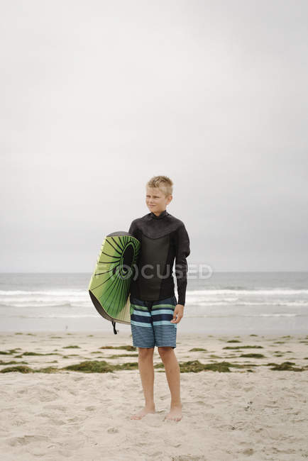 Garçon debout sur la plage de sable — Photo de stock