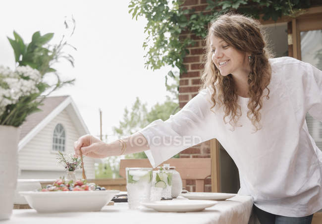 Femme debout près d'une table — Photo de stock