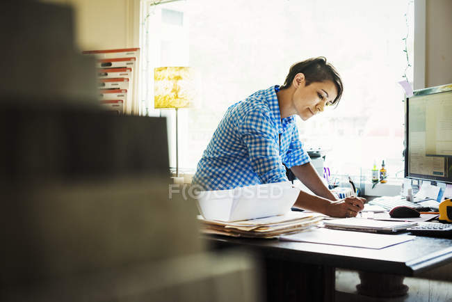 Frau arbeitet am Schreibtisch im Innenstudio — Stockfoto