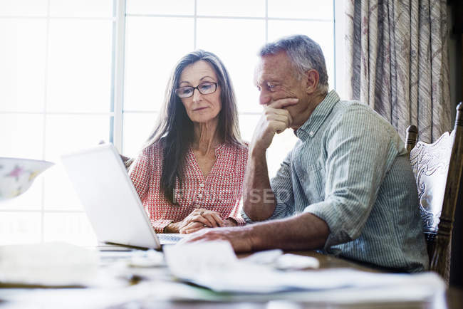 Couple aîné avec paperasse et factures — Photo de stock