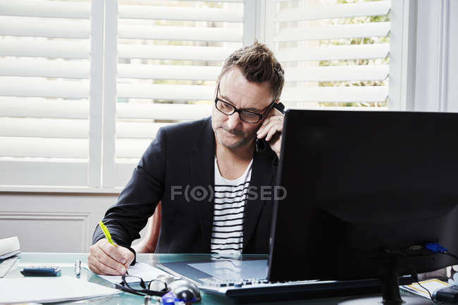 Geschäftsmann sitzt am Schreibtisch im Büro — Stockfoto
