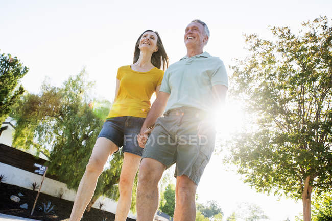 Seniorenpaar läuft eine Straße entlang — Stockfoto