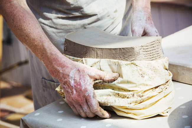 Жінка-гончар розгортає мішок з глини — стокове фото