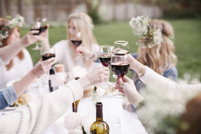 Frauen stoßen mit Rotwein an. — Stockfoto