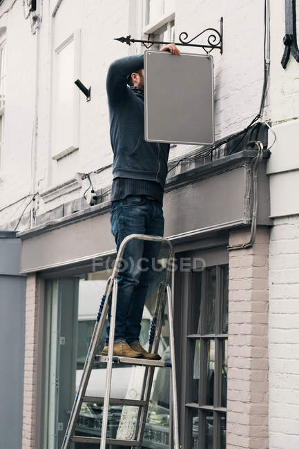 Homem que fixa um sinal de nome pintado — Fotografia de Stock
