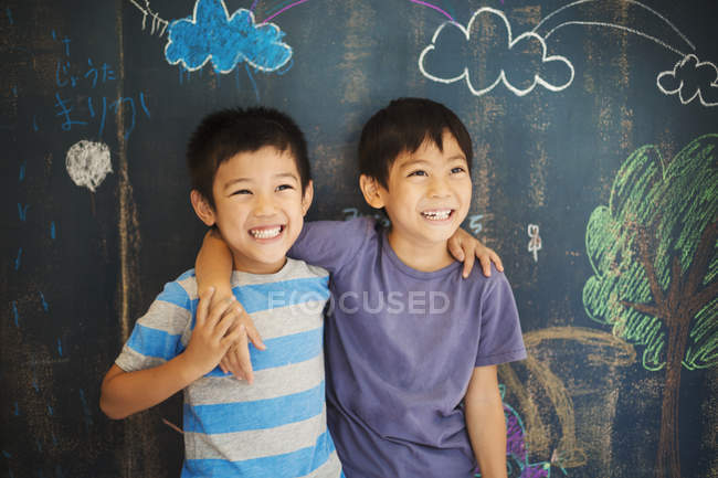 Meninos em pé por uma escola de quadro-negro — Fotografia de Stock