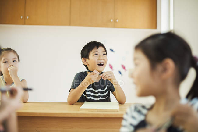 Boy and two girls in a classroom. — Stock Photo