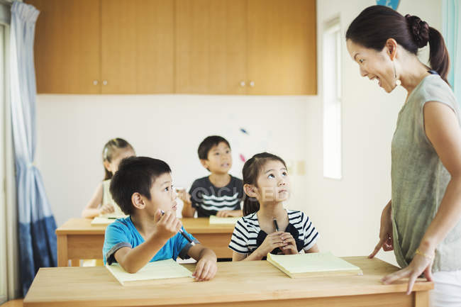 Kinder im Klassenzimmer mit Lehrer. — Stockfoto