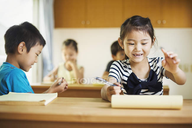 Enfants travaillant ensemble dans une salle de classe — Photo de stock