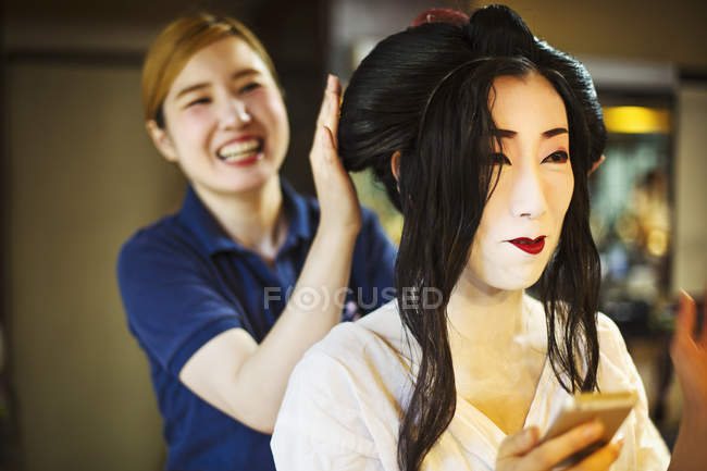Geisha con un capello e make up artist — Foto stock