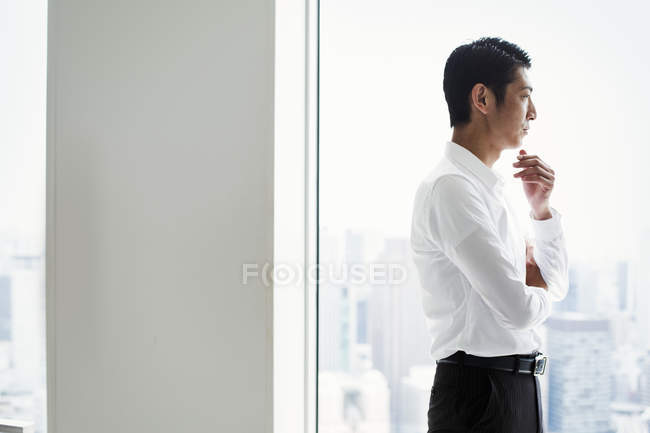 Бізнесмен в офісі стоїть біля вікна — стокове фото