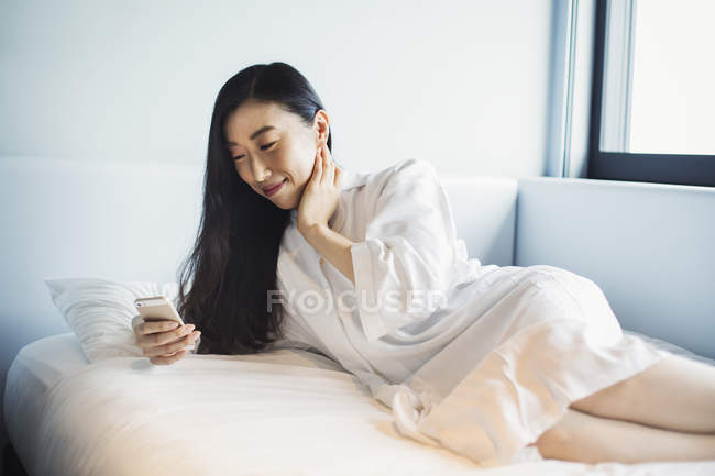 Mujer en la cama en un hotel - foto de stock