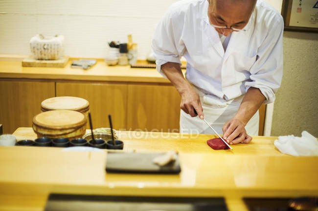Chef de corte de peixe para fazer sushi — Fotografia de Stock