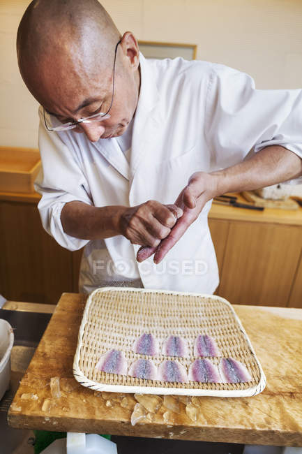 Chef fazendo sushi, preparando peixe . — Fotografia de Stock