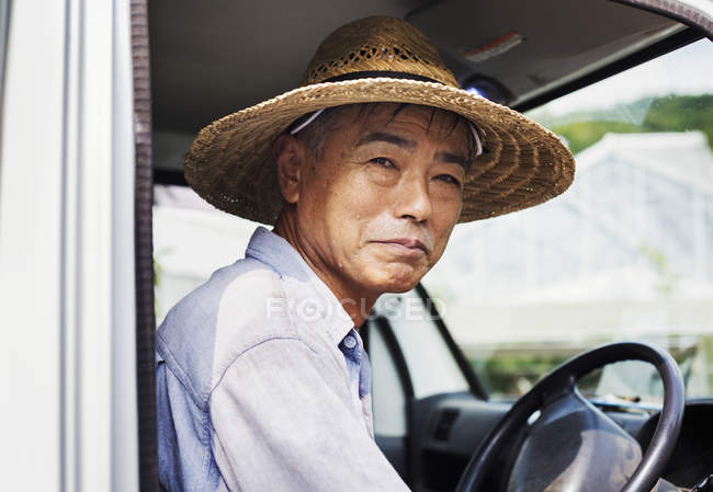 Man in a hat sitting in truck. — Stock Photo