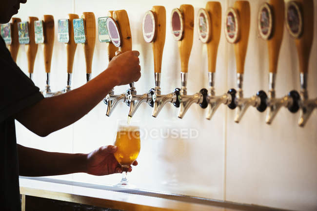 Homem puxando um copo de cerveja — Fotografia de Stock