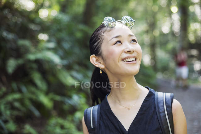 Усміхнена жінка стоїть в лісі . — стокове фото