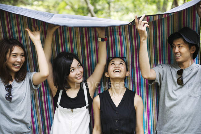 People standing in a forest with picnic rug — Stock Photo