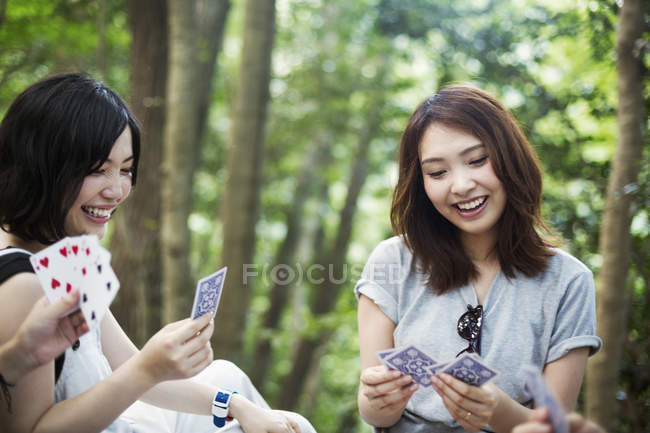 Women playing cards in a forest. — Stock Photo