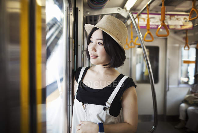 Frau mit Hut im Zug unterwegs. — Stockfoto