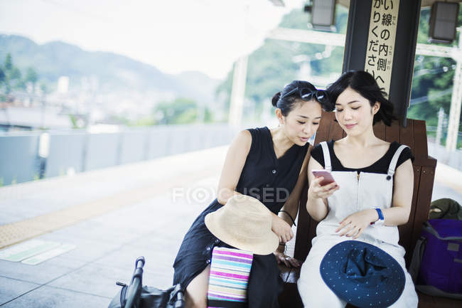 Frauen, die auf ein Handy schauen. — Stockfoto