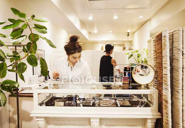 Mujer trabajando en una boutique de moda - foto de stock