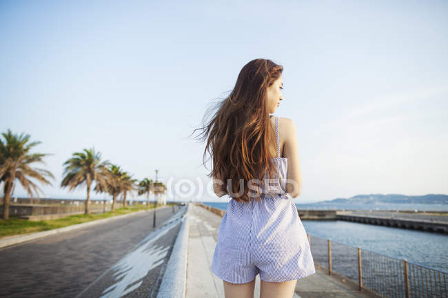 Женщина, стоящая у дороги на побережье
. — стоковое фото