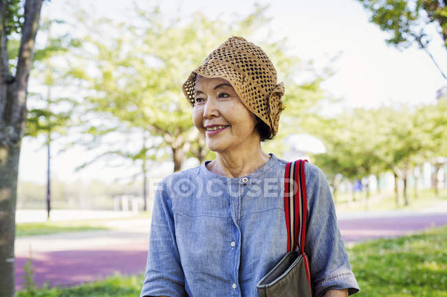 Anziana donna indossa un cappello all'uncinetto
. — Foto stock