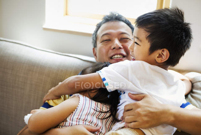Homem abraçando sua filha e filho — Fotografia de Stock
