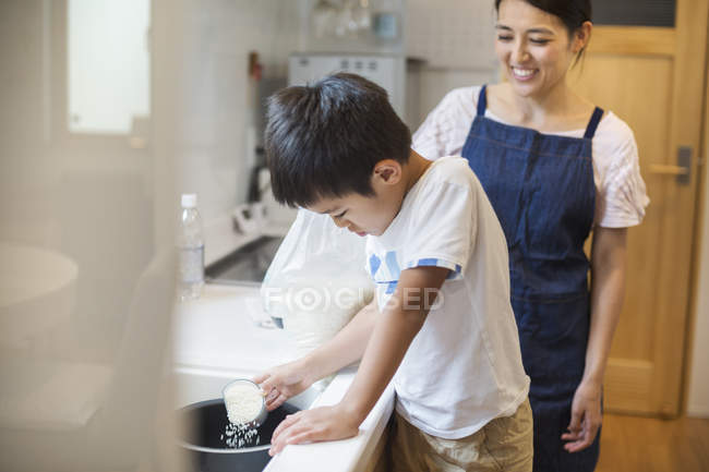 Mother and son standing at a sink. — Stock Photo