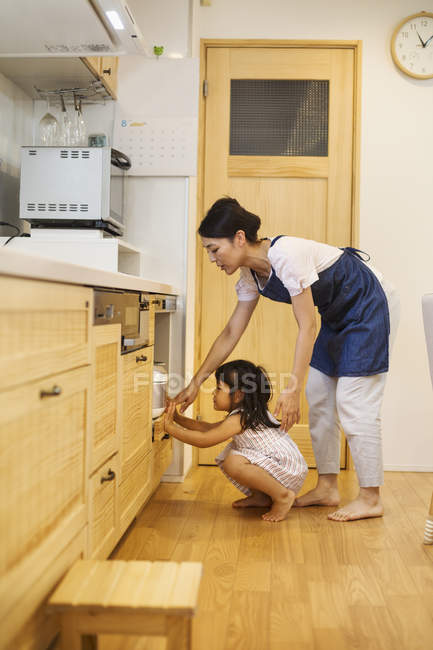 Frau und ein Mädchen schauen in den Ofen. — Stockfoto