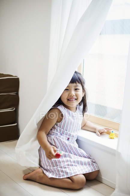 Девушка, играющая у окна — стоковое фото
