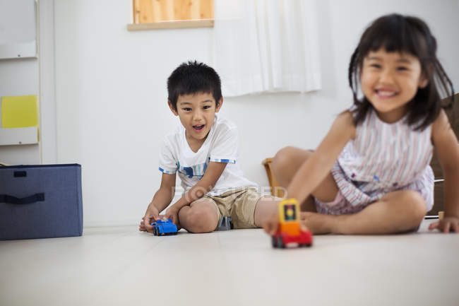 Bambini che giocano con i giocattoli sul pavimento. — Foto stock