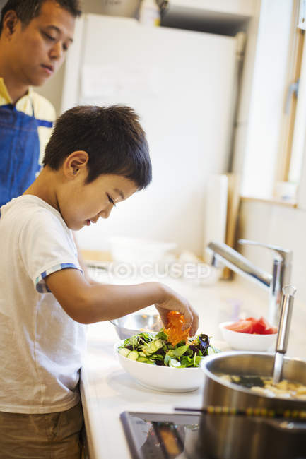 Hombre preparando una comida con su hijo . - foto de stock