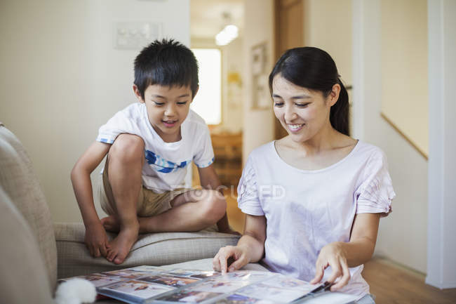 Woman and son looking at a photographic album. — Stock Photo